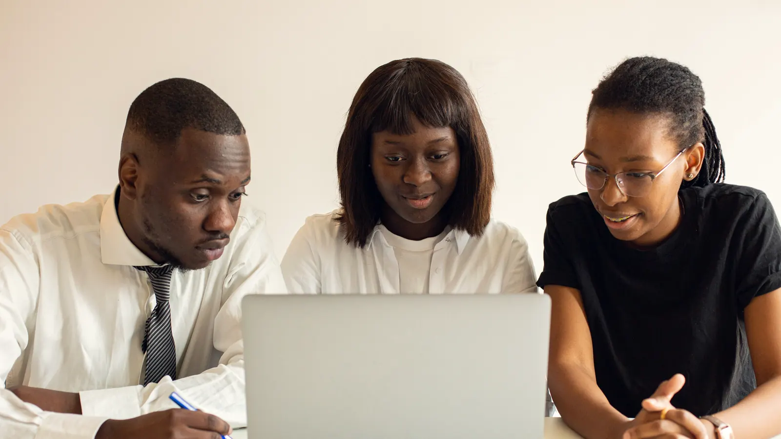 Three colleagues working together at a laptop