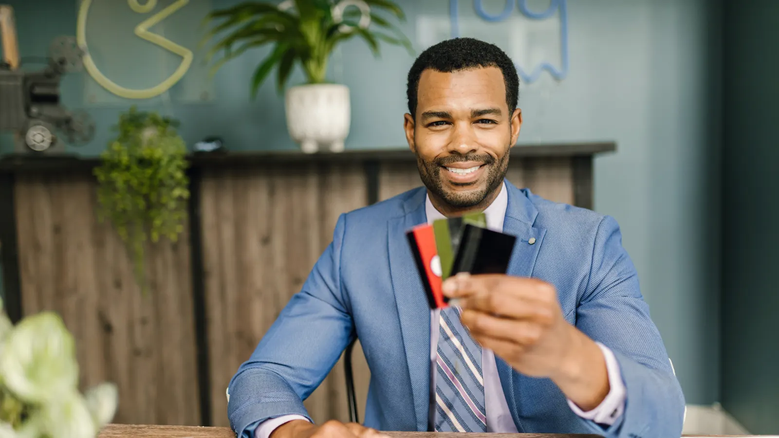 A smiling man in a suit at a service desk